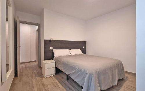 a bedroom with a large bed and a wooden floor at Costa azul - 3 Izquierda in Puerto Naos