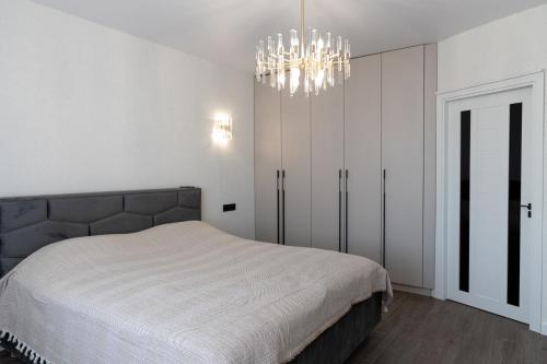 a bedroom with a bed and a chandelier at Royal Boulevard Residence in Chişinău