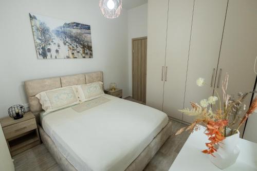 a bedroom with a white bed and a white cabinet at Aurum Residence in Volos