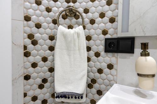 a bathroom with a white towel hanging on a wall at Royal Boulevard Residence in Chişinău