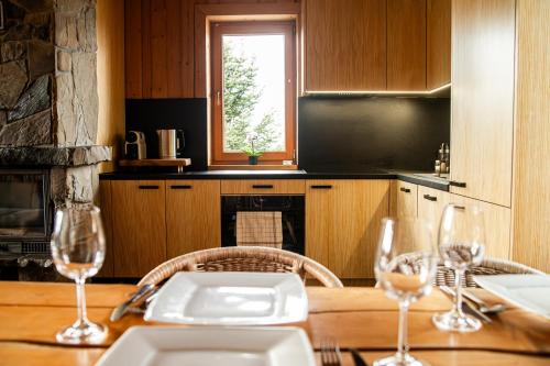 a kitchen with a wooden table with wine glasses at Miętowa Osada Czerwienne in Ciche