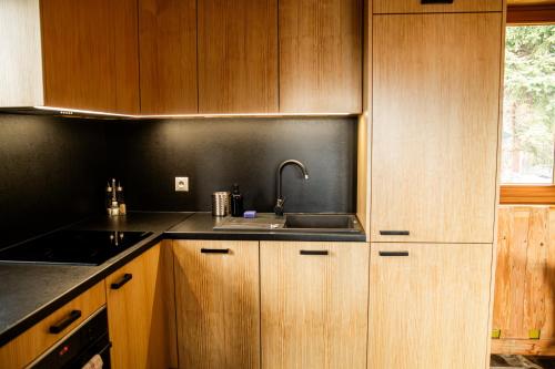 a kitchen with a sink and wooden cabinets at Miętowa Osada Czerwienne in Ciche