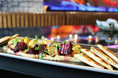 a plate of food with a pizza and some fries at The Midland Hotel, Chicago, a Tribute Portfolio Hotel in Chicago