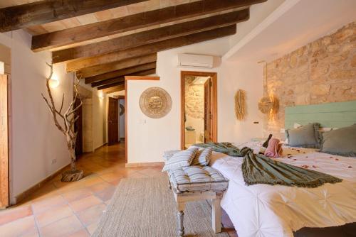 a bedroom with a large bed and a stone wall at Hotelet Can Oms Picasso by Rentallorca in Petra