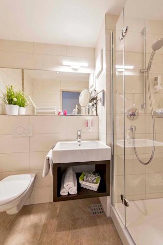 a bathroom with a sink and a shower at Garni Hotel Schumacher in Filderstadt