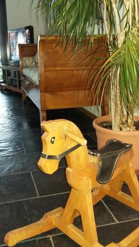 a wooden rocking horse in front of a piano at B&B Il Vigneto in Melano