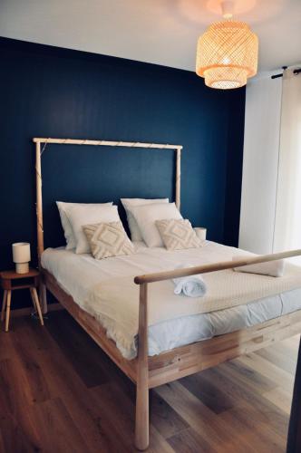 une chambre avec un lit avec un mur bleu dans l'établissement Le Rêve Bleu Jardin Parking Aéroport MEETT, à Blagnac