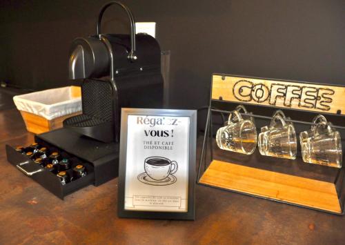 - une table avec une boîte de café et une boîte de vin dans l'établissement Le Rêve Bleu Jardin Parking Aéroport MEETT, à Blagnac