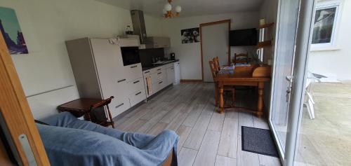 une cuisine avec une table et un réfrigérateur dans l'établissement MAISON plain-pied au calme à proximité de l'aéroport cdg et du parc disney, à Mitry-Mory