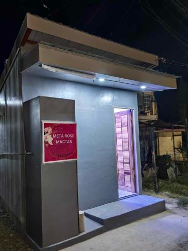 a small house with a door and a sign on it at Meta Rose Mactan Residences in Buaya
