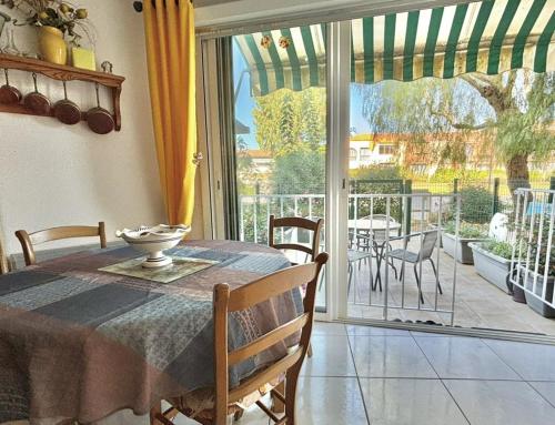 une salle à manger avec une table et des chaises et un balcon dans l'établissement STUDIO cabine 2 couchages à LA LONDE LES MAURES LAL110-004, à La Londe-les-Maures