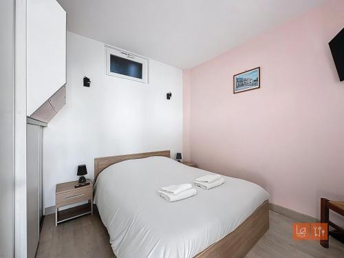 une chambre blanche avec un lit et une télévision dans l'établissement Le Cocon Marin, à Boulogne-sur-Mer