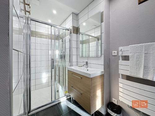 une salle de bain avec un lavabo et une douche en verre dans l'établissement Le Cocon Marin, à Boulogne-sur-Mer