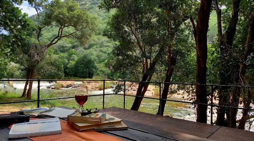 a table with a glass of wine and a book at House On Blyde in Kampersrus AH