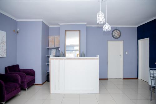 a living room with blue walls and a counter at Avenue Inn in Gaborone