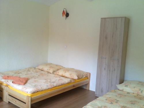 a bedroom with two beds and a wooden cabinet at Penzion Apartmány Bečov in Bečov nad Teplou