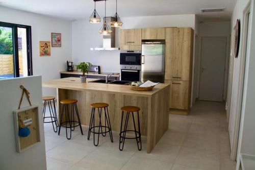 une cuisine avec un îlot et des tabourets de bar dans l'établissement Villa familiale Luberon 3ch calme jardin parking, à Saignon