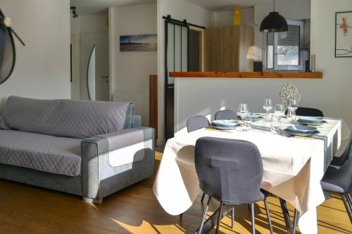 une salle à manger avec une table et un canapé dans l'établissement maison de vacances 4 pers jardin agreable - Olonne sur mer, à Olonne-sur-Mer