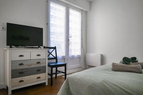 une chambre avec un lit et une télévision sur une commode dans l'établissement maison de vacances 4 pers jardin agreable - Olonne sur mer, à Olonne-sur-Mer