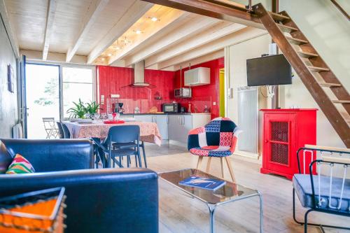 - un salon avec des murs rouges et des chaises bleues dans l'établissement charmante maisonnette proche chenal - 5 personnes, à Les Sables-dʼOlonne