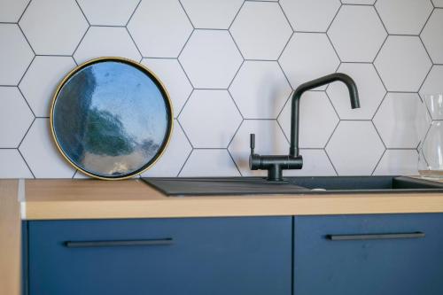 - une cuisine avec un évier et un miroir sur un comptoir dans l'établissement maison entierement renovee face au chenal pour 4 pers - la chaume, à Les Sables-dʼOlonne