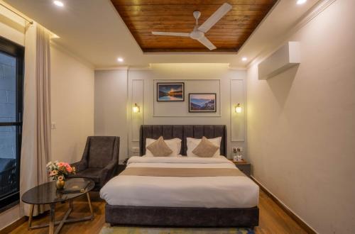 a bedroom with a large bed and a chair at Perfectstayz Premium Westend at Mall Road in Mussoorie