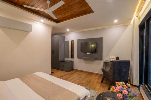 a bedroom with a bed and a desk and a tv at Perfectstayz Premium Westend at Mall Road in Mussoorie