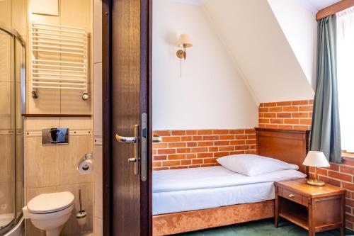 a small room with a bed and a bathroom at Hotel Szymbark in Szymbark
