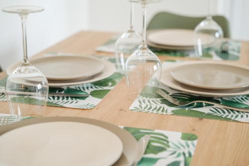une table en bois avec des assiettes et des verres à vin dessus dans l'établissement superbe appartement entierement renove - proche plage - quartier presidents, à Les Sables-dʼOlonne