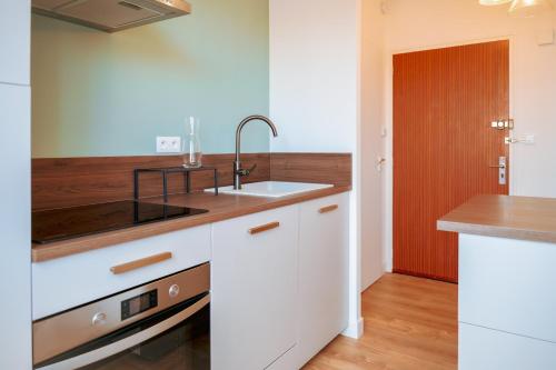 une cuisine avec des armoires blanches et un évier dans l'établissement superbe appartement entierement renove - proche plage - quartier presidents, à Les Sables-dʼOlonne