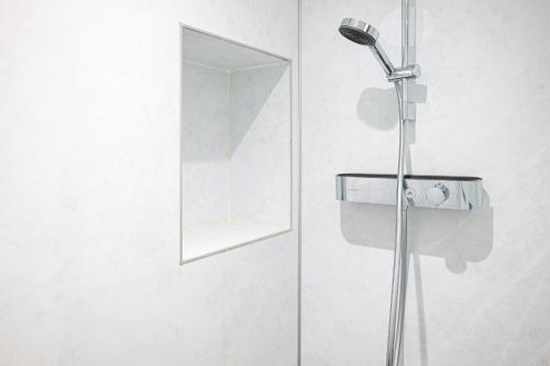 d'une douche avec un miroir et un pommeau de douche. dans l'établissement Maison de pêcheur rénovée - 3 chambres et patio extérieur - 6 personnes, à Les Sables-dʼOlonne