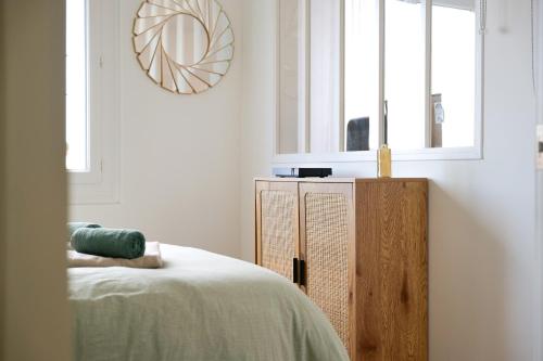 une chambre avec un lit et une armoire en bois dans l'établissement superbe appartement entierement renove - proche plage - quartier presidents, à Les Sables-dʼOlonne