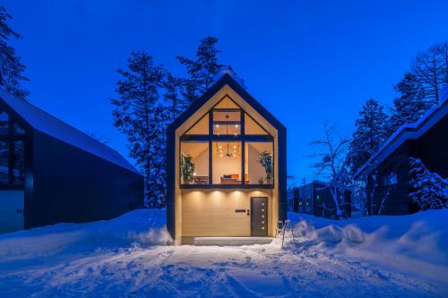 a small house in the snow at night at Prominence by The Hakuba Collection in Hakuba