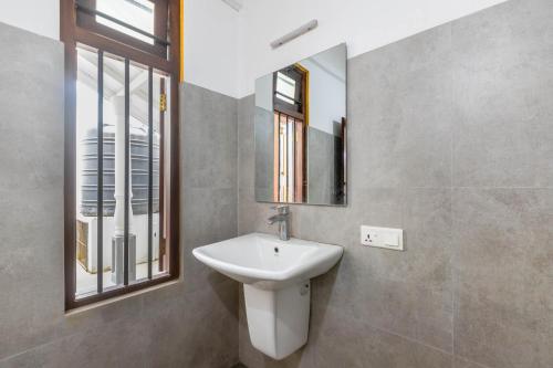 a bathroom with a sink and a mirror at Pleasure Villa in Matara