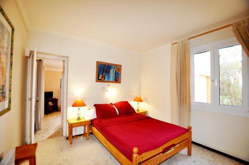 - une chambre avec un lit rouge et une fenêtre dans l'établissement Argelès, Sea View & Pool, à Argelès-sur-Mer