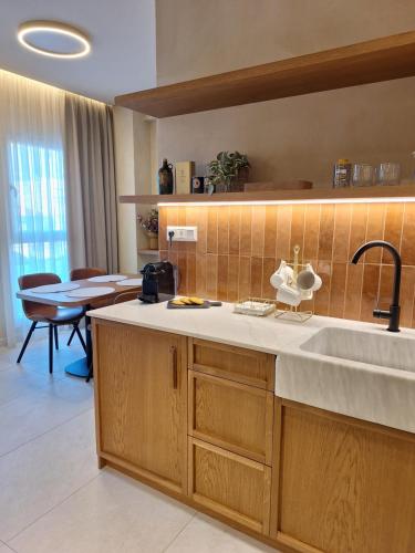 a kitchen with a sink and a table in a room at CENTAURO Prime Residencies in Volos