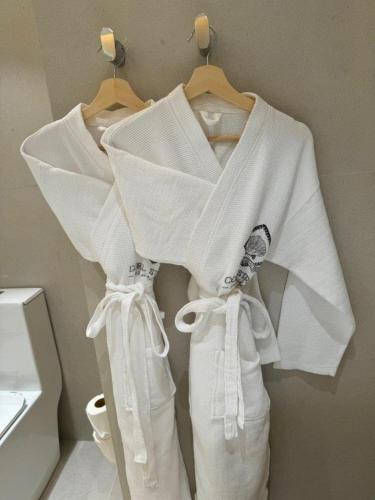 a white robe hanging on a rack in a bathroom at Coral Strand Smart Choice in Beau Vallon