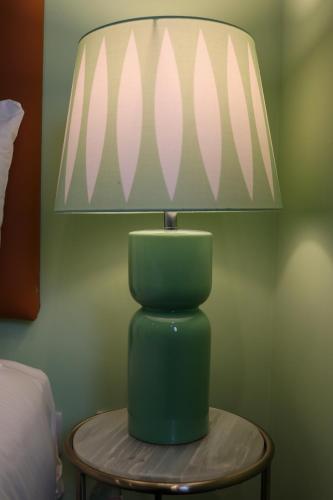 a green lamp on a table next to a bed at Sunday Street Boutique in Drogheda