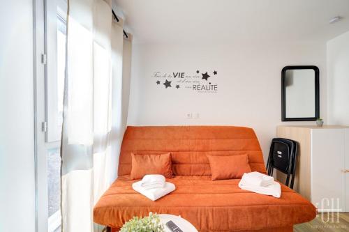 - un lit orange dans une petite chambre avec un miroir dans l'établissement Jupiter - Proche A10 - 2V - Parking, à Saint-Pierre-des-Corps