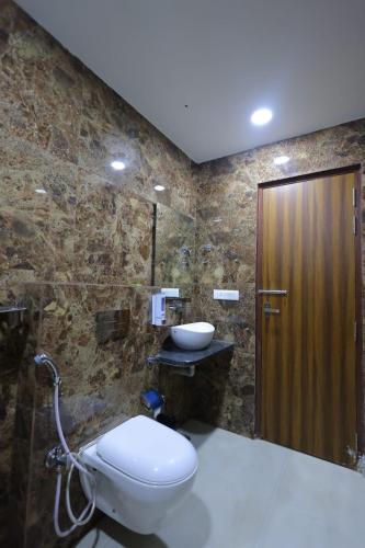 a bathroom with a toilet and a sink at The Grand Tree Hotel in Agra
