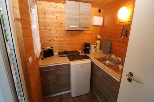 a small kitchen with a sink and a counter at Bungalow WALD & SAND direkt am Strand in Dranske