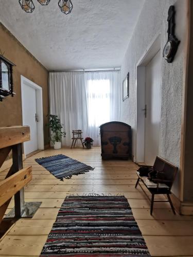 a living room with a large window and a rug at Pension im Tal der Stille in Treseburg