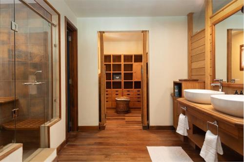 un bagno con due lavandini e una doccia in vetro di Villa Itzaga by muse villas a Post of Flacq