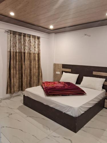 a bedroom with a bed with a red blanket on it at Badrish Kailasham By StayApart in Badrīnāth