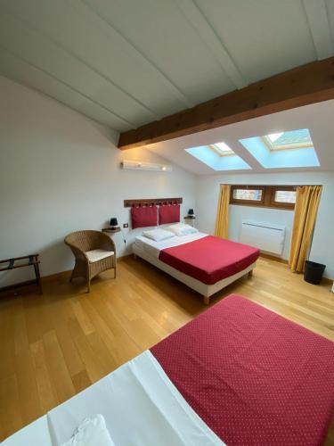 une chambre avec un grand lit avec une couverture rouge dans l'établissement auberge des trois ami-es, à Vinezac