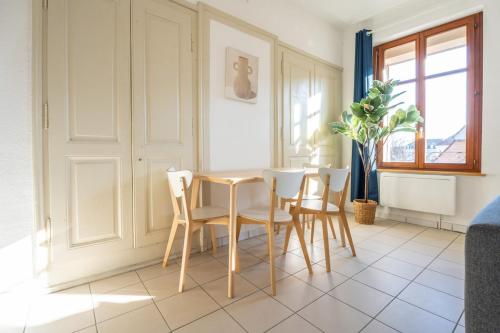 une salle à manger avec une table et quatre chaises dans l'établissement Super Logement 6pers Stationnement Gratuit Centre, à Mulhouse