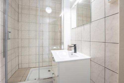 une salle de bain blanche avec un lavabo et une douche dans l'établissement Super Logement 6pers Stationnement Gratuit Centre, à Mulhouse