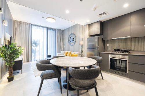 a kitchen with a table and chairs in a room at 2BR The Al Jada Dream by Blue Cloud Holidays in Sharjah