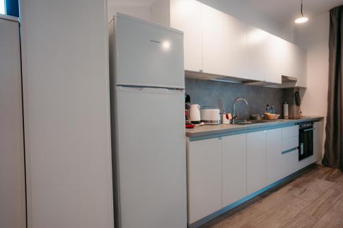 a kitchen with a white refrigerator in a room at ResHome Apartments&Rooms in Focşani