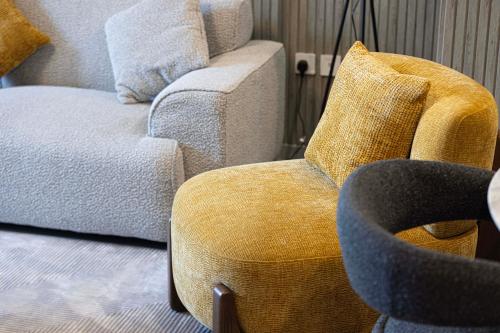 a living room with a couch and a chair at 2BR The Al Jada Dream by Blue Cloud Holidays in Sharjah